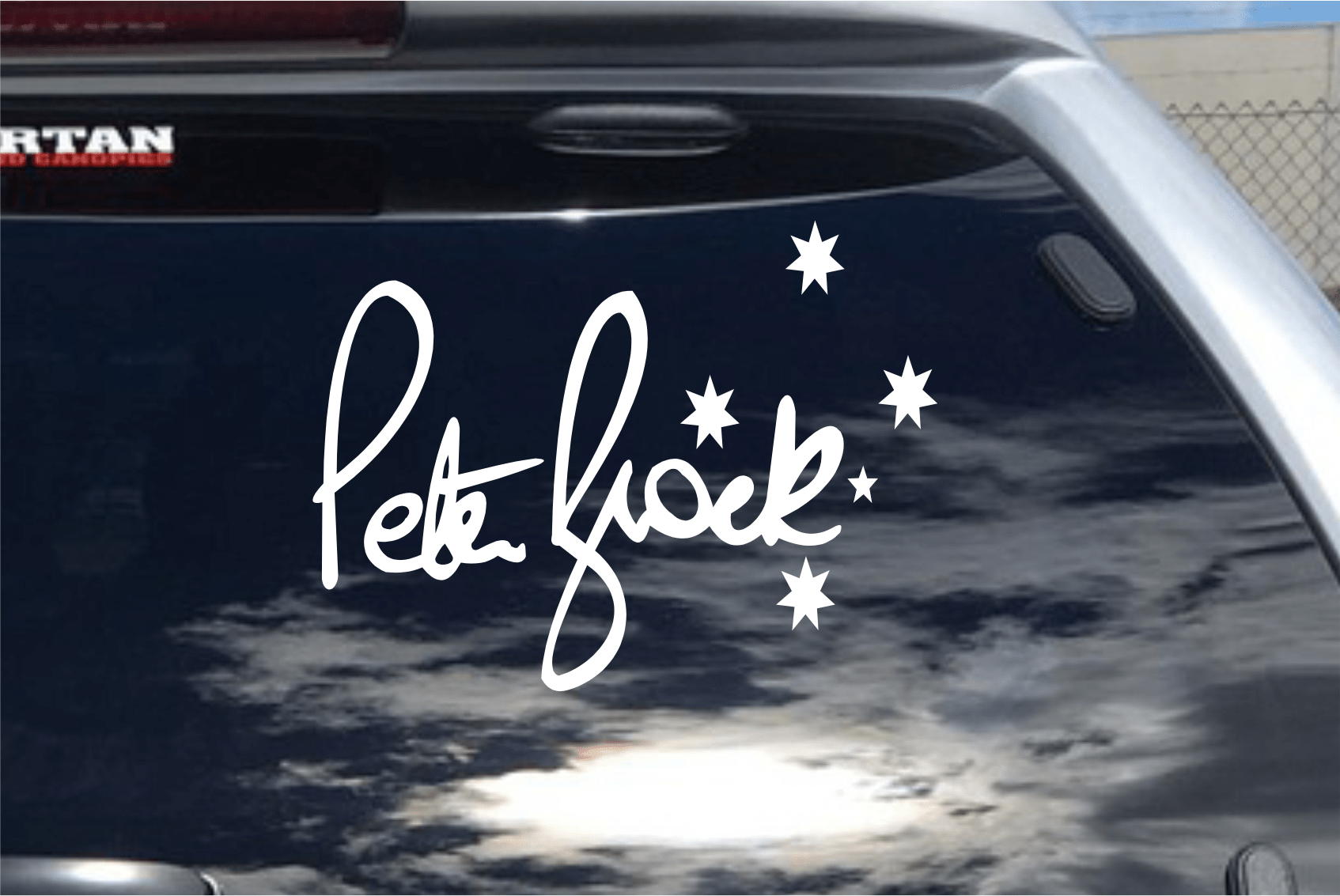 Car window with 'Pete Flock' decal and star decorations