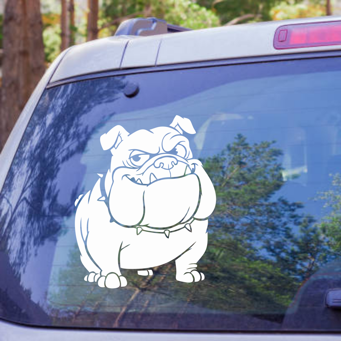 Bulldog decal on a car window with trees in the background