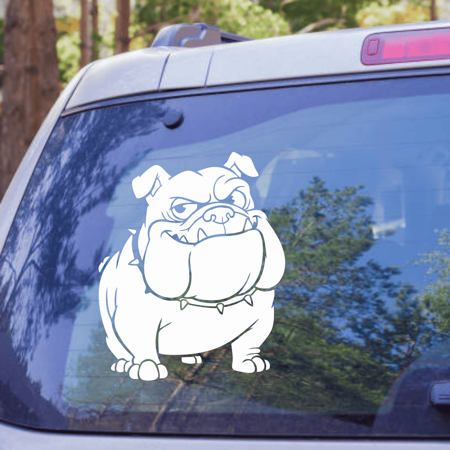 Bulldog decal on a car window with trees in the background