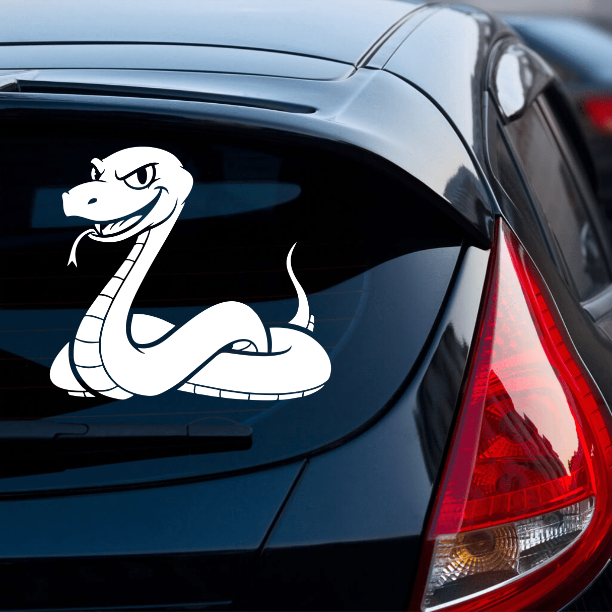 Car with a snake decal on the back window, parked on a street.