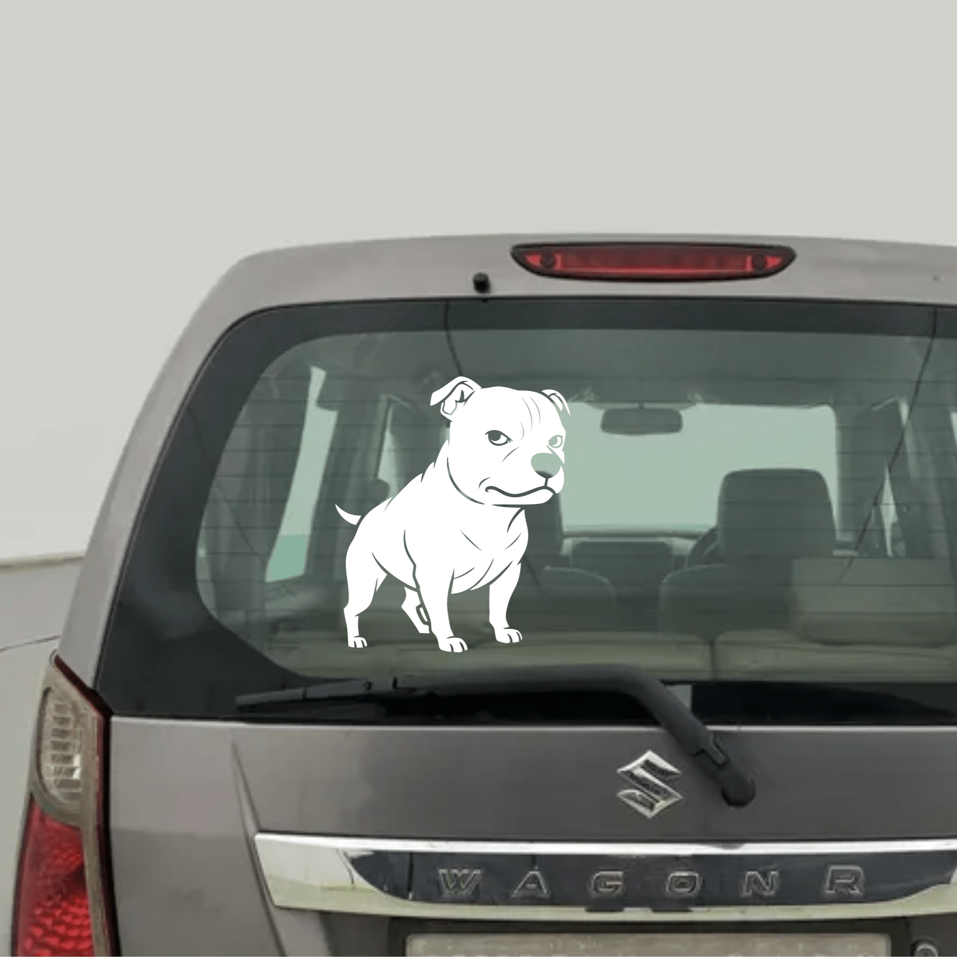 Car with a Staffy dog decal on the rear window against a white background