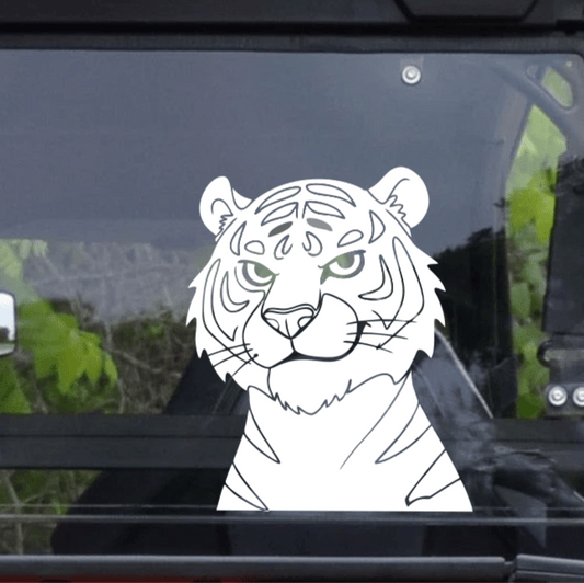 White tiger decal on a car window with a blurred outdoor background
