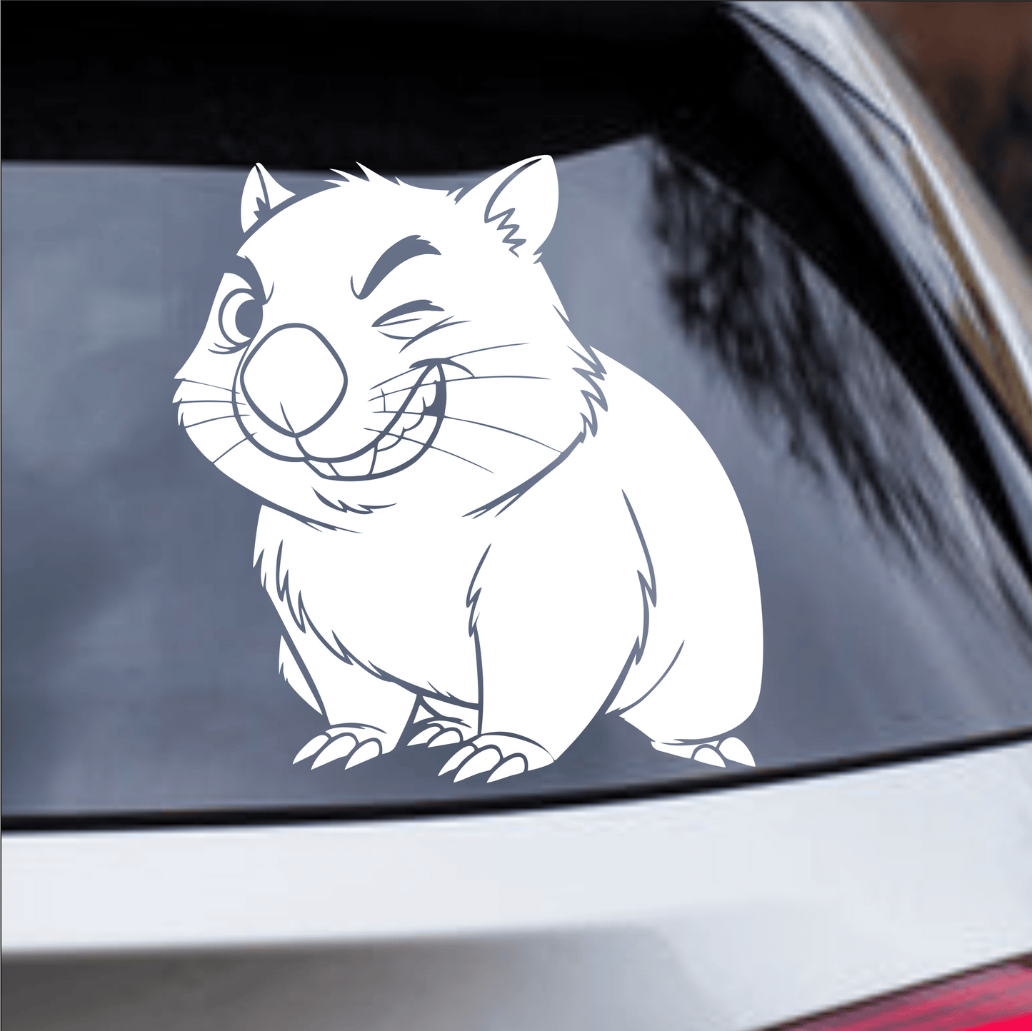Car window with a white cartoon-style wombat decal