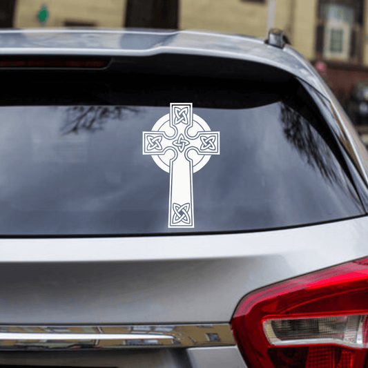 Celtic cross decal on a car window with a blurred background