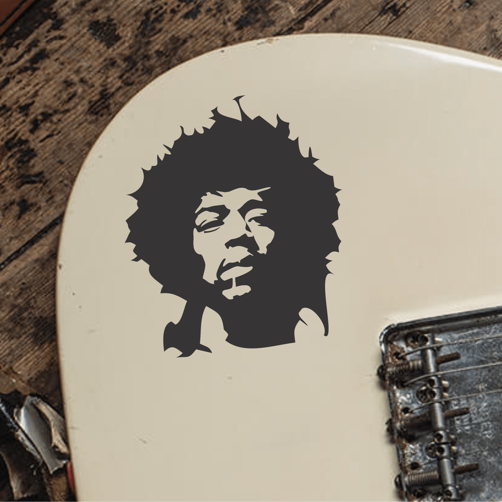 Electric guitar with a Jimi Hendrix portrait decal on a wooden surface