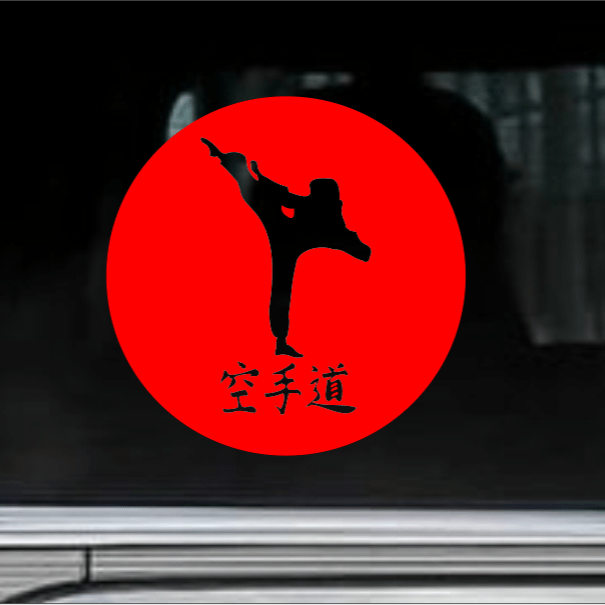 Decal of a person in a martial arts pose on a red circle with kanji text, mounted on a car window.
