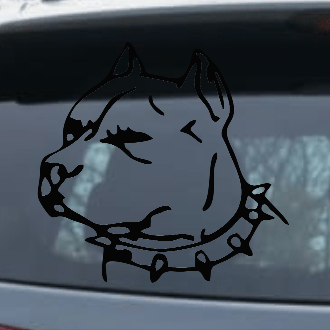 Black dog decal with spiked collar on a car window