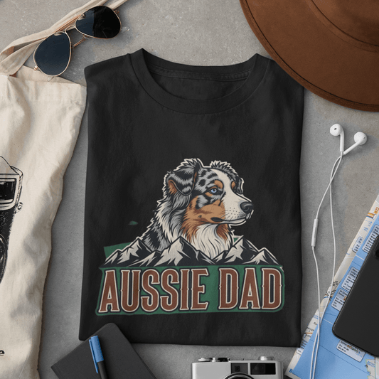 Black sweatshirt with 'Aussie Dad' design on a gray surface with accessories.