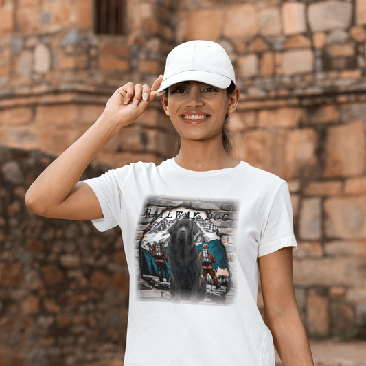 Woman wearing a white t-shirt with a Newfoundland t-shirt design, standing in front of a stone wall.