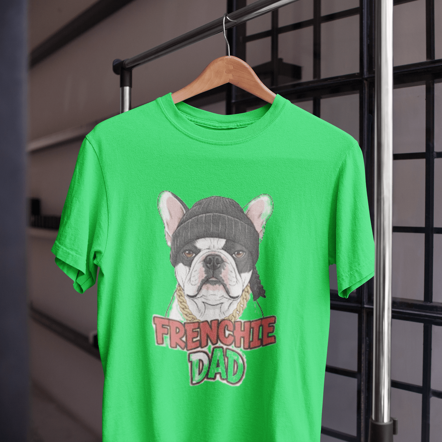 Green t-shirt with a dog graphic and 'FRENCHIE DAD' text on a hanger.