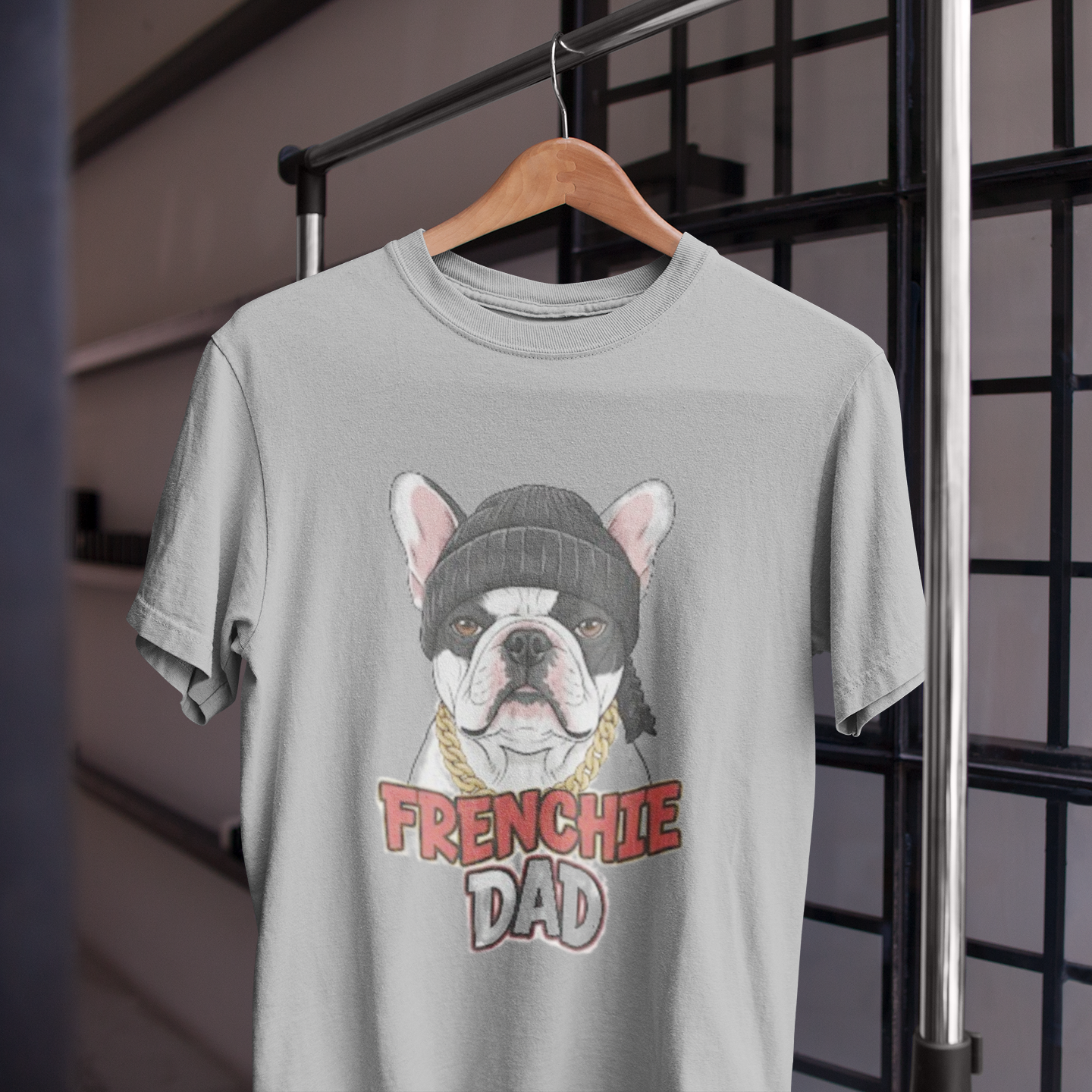 Gray t-shirt with a dog graphic and 'FRENCHIE DAD' text on a hanger.