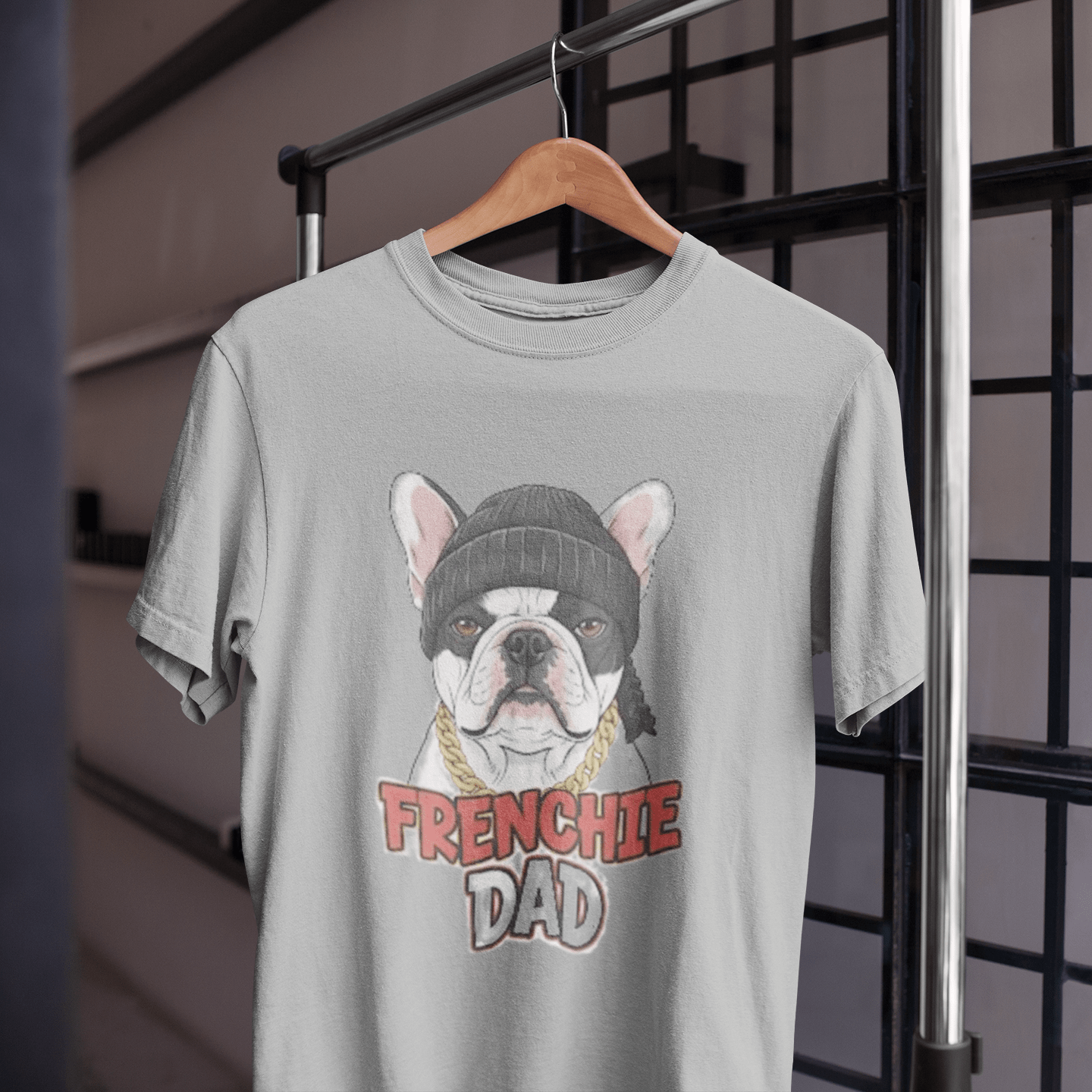 Gray t-shirt with a dog graphic and 'FRENCHIE DAD' text on a hanger.