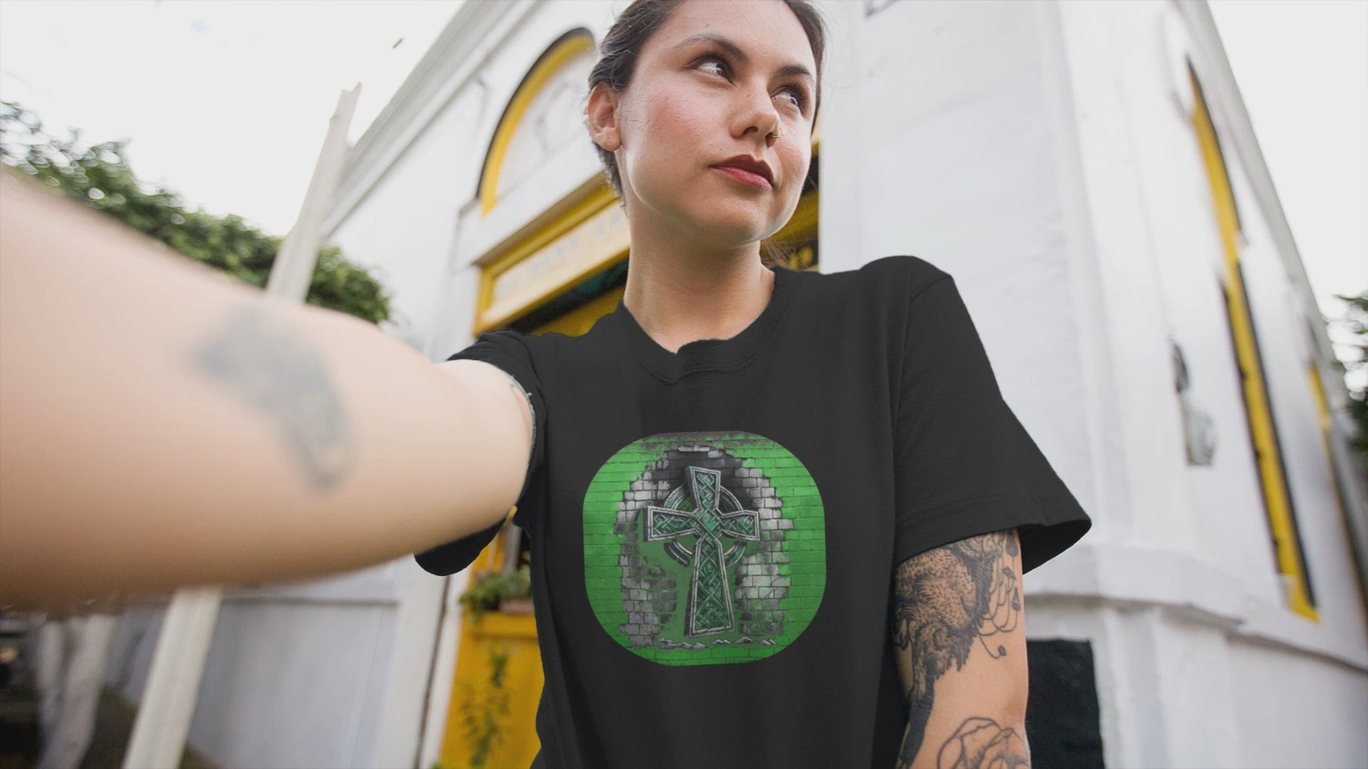 Graphic T-shirt featuring a Celtic cross depicted in graffiti style, with vibrant colors and urban art elements.