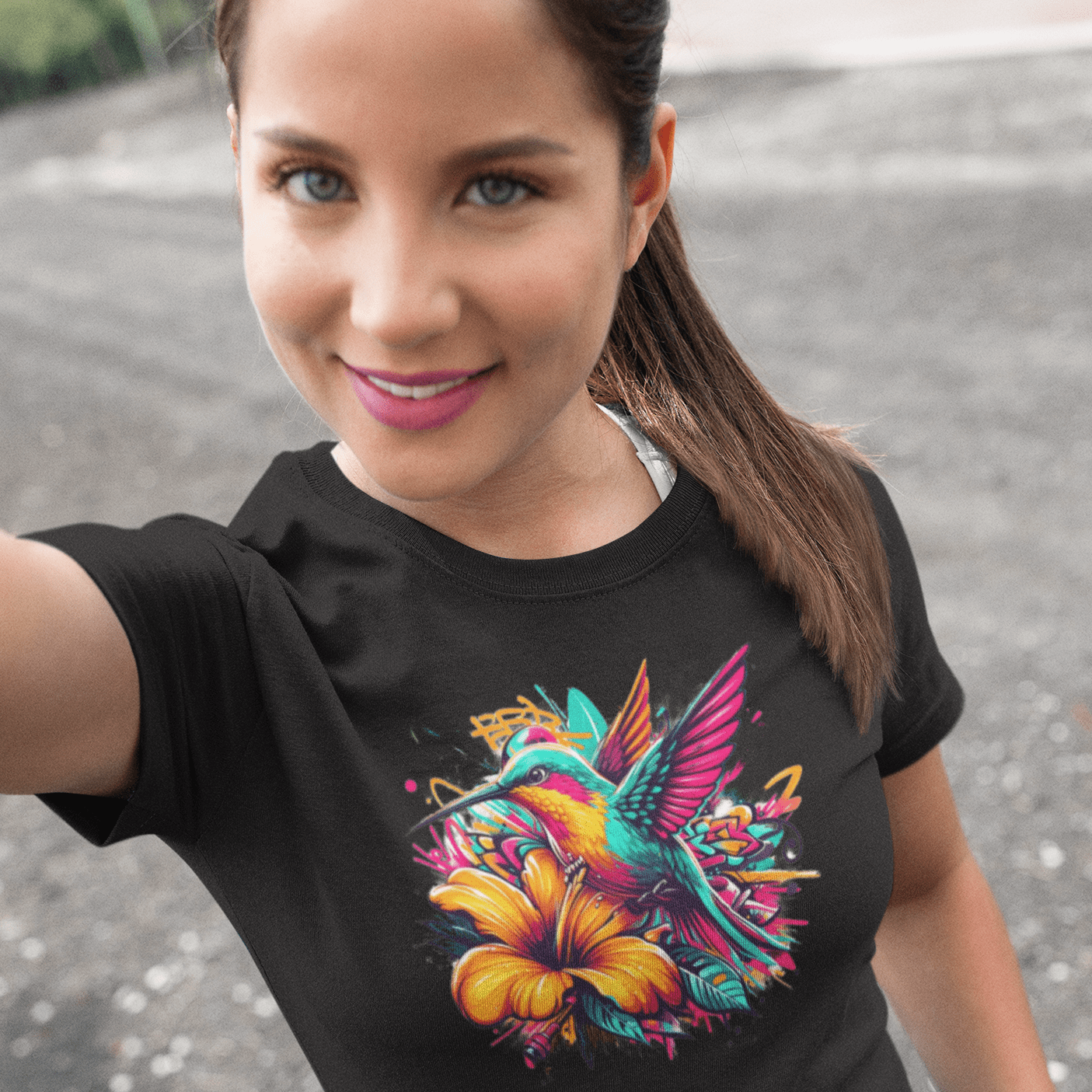 Graphic T-shirt featuring a colorful hummingbird surrounded by intricate floral designs, rendered in vibrant hues.