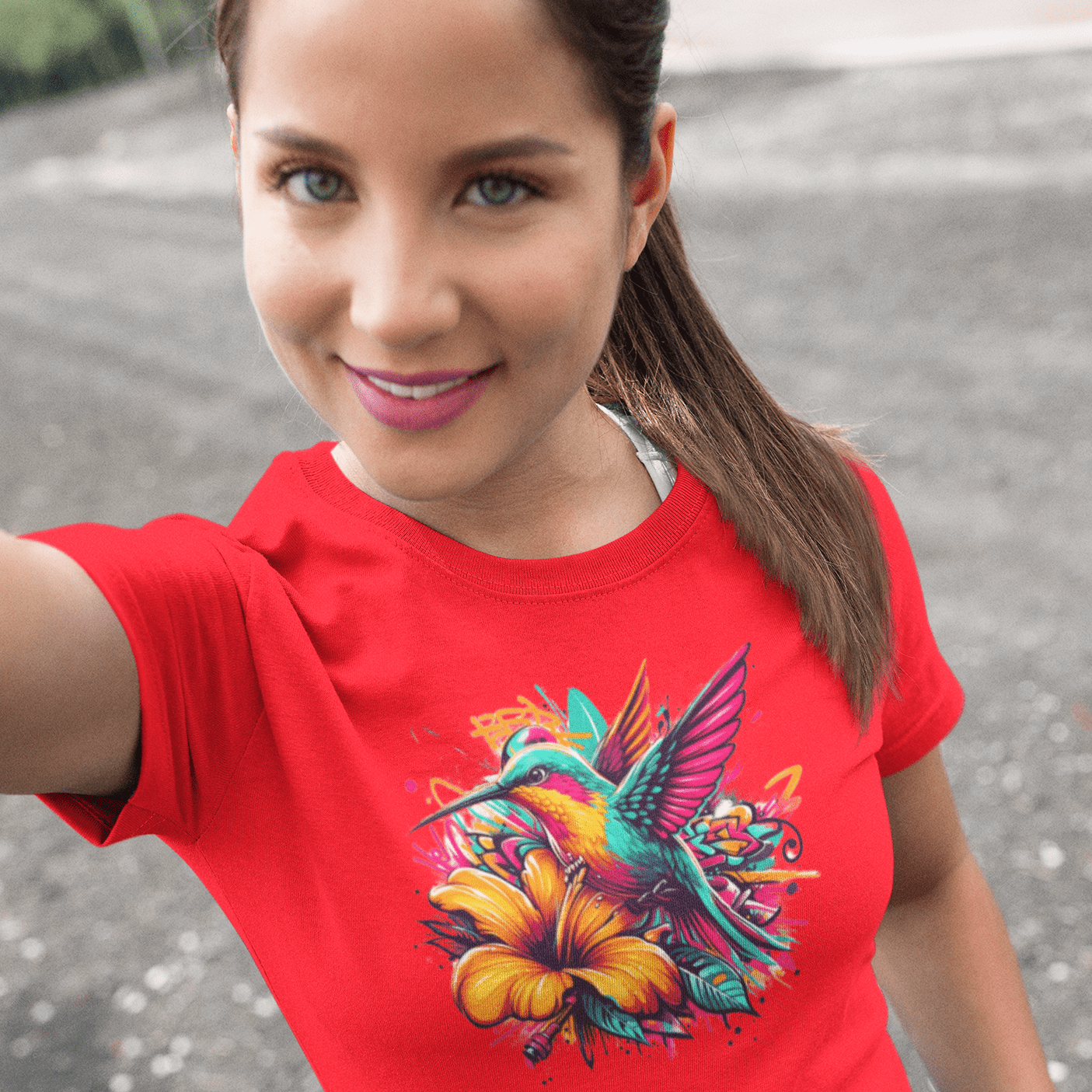 Graphic T-shirt featuring a colorful hummingbird surrounded by intricate floral designs, rendered in vibrant hues.