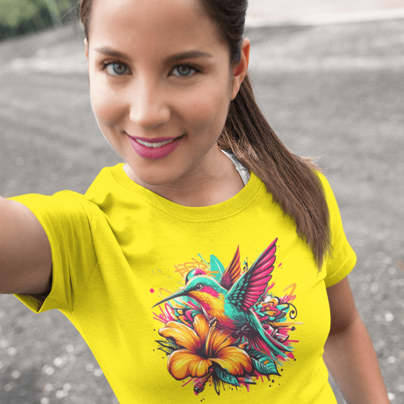 Graphic T-shirt featuring a colorful hummingbird surrounded by intricate floral designs, rendered in vibrant hues.