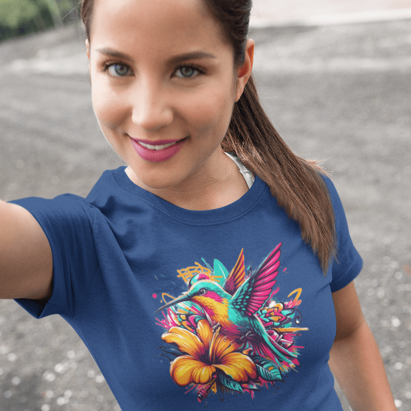 Graphic T-shirt featuring a colorful hummingbird surrounded by intricate floral designs, rendered in vibrant hues.