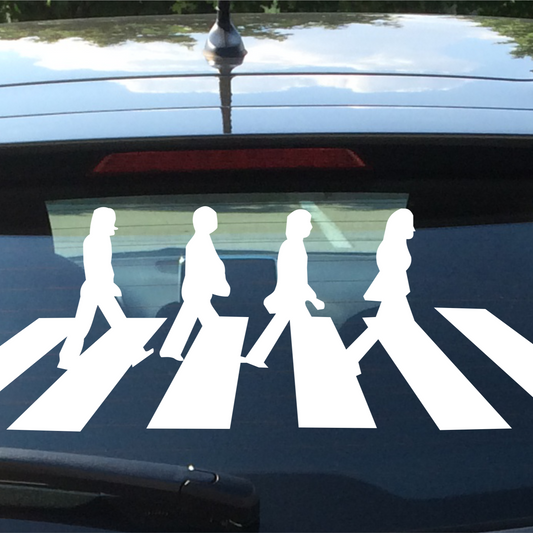 Car window with a white 'Abbey Road' decal of four figures on a zebra crossing.