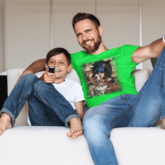 Father and son smiling on a couch while the man wears a  graphic t-shirt featuring a Basset Hound dog in front of a rustic brick wall street art mural.