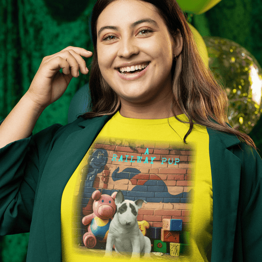 graphic t-shirt featuring an English Bull Terrier puppy surrounded by toy blocks and a stuffed pig against a brick wall with teal "A Railway Pup" text.
