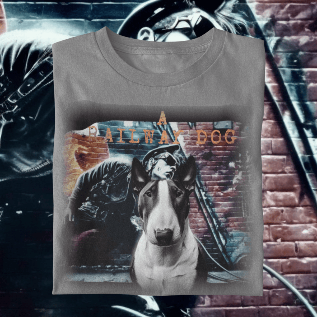 graphic t-shirt featuring an English Bull Terrier in front of a vintage motorcycle rider brick mural with text reading "A Railway Dog."