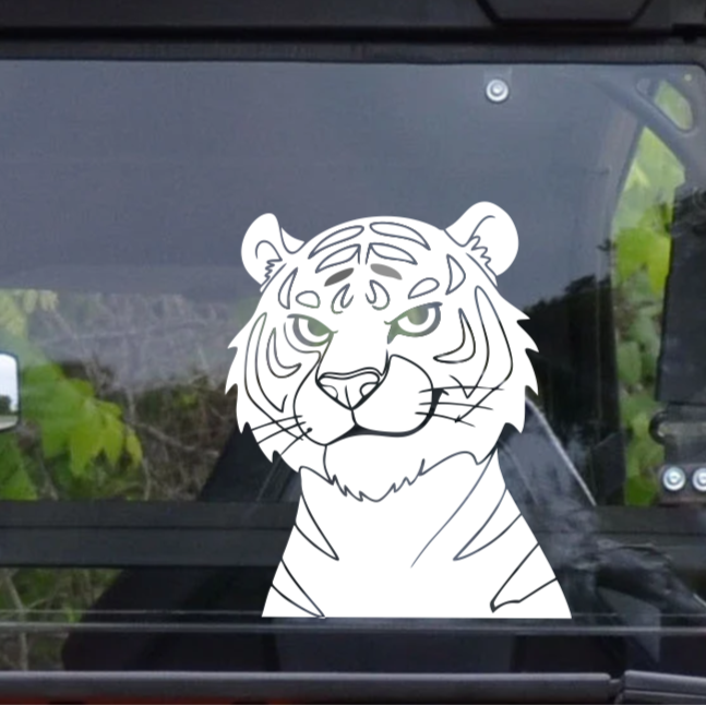 White tiger decal on a car window with a blurred outdoor background