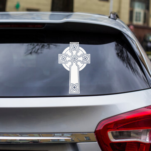 Celtic cross decal on a car window with a blurred background