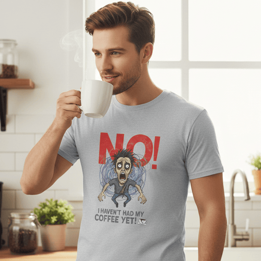 Man in a kitchen wearing a t-shirt with a humorous coffee-themed design.