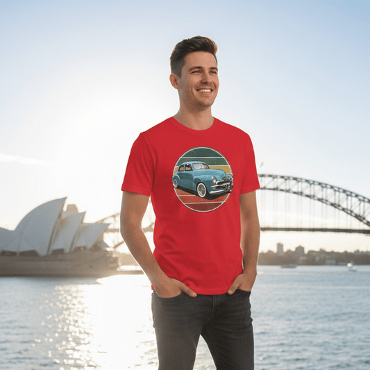 Man wearing a red FJ Holden t-shirt with a graphic design, standing in front of the Sydney Harbour Bridge and Opera House.