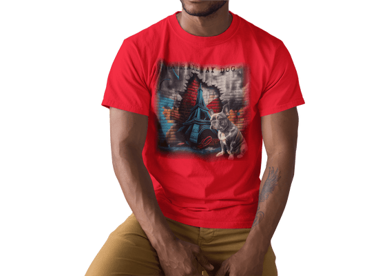 Young man wearing a bright red graphic t-shirt featuring a French Bulldog sitting in front of an urban brick wall cutout revealing the Eiffel Tower with "A Railway Dog" stencil text.