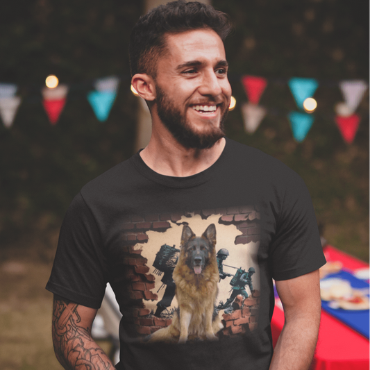 Smiling bearded man wearing a black crew-neck t-shirt featuring a detailed German Shepherd dog sitting in front of a broken brick wall graphic with soldiers in combat gear.