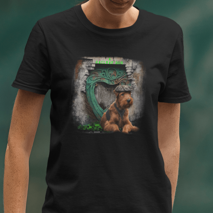 Close-up of a woman wearing a black graphic t-shirt featuring an Irish Terrier dog wearing a flat cap, seated in front of a stone archway with a green Celtic harp and "A Railway Dog" text.