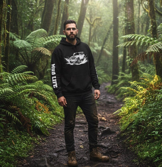 Man in a forest wearing a hoodie with text and graphics