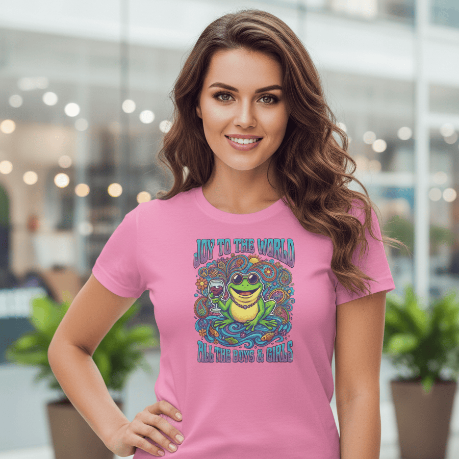 Woman wearing a pink t-shirt with a colorful frog graphic design in an indoor setting.