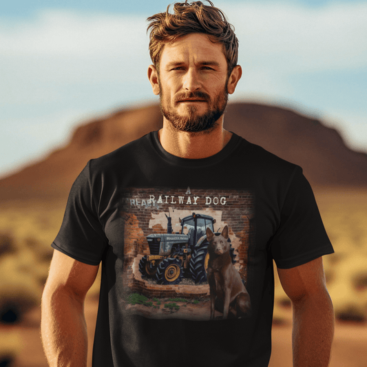 graphic t-shirt featuring an Australian Kelpie sitting in front of a blue farm tractor brick mural with text reading "A Railway Dog."