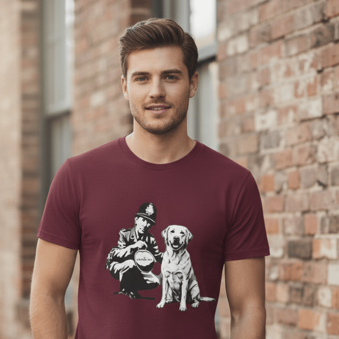 Man wearing a maroon t-shirt with a graphic design of a person and a dog, standing against a brick wall.