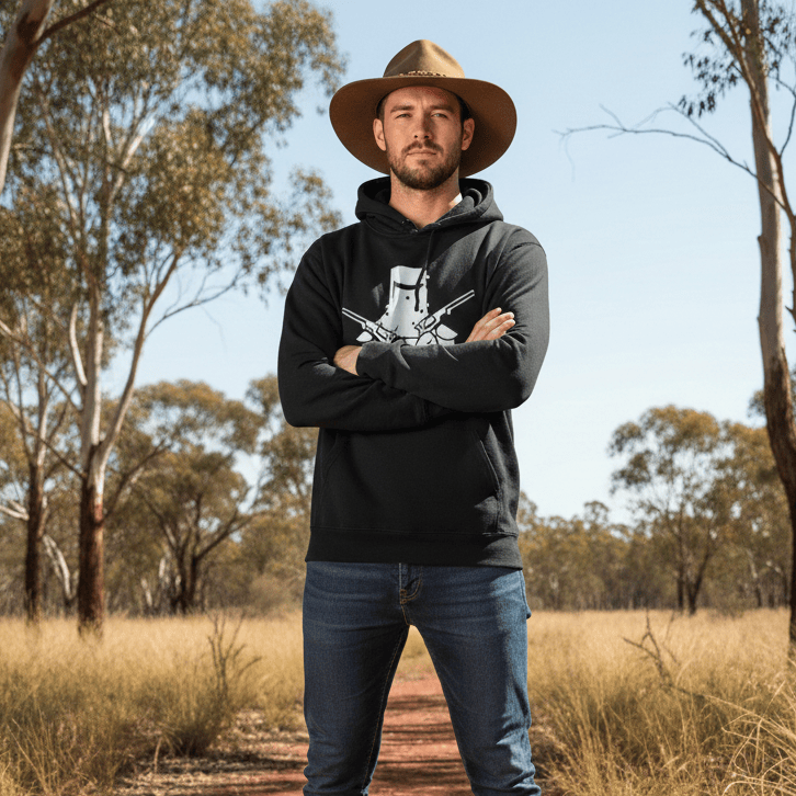 He is wearing a black hoodie featuring a white graphic of a Ned Kelly-style iron helmet with two crossed pistols.