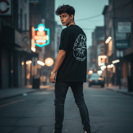 Person wearing a black Off Axis band t-shirt with a graphic design on a city street at night.