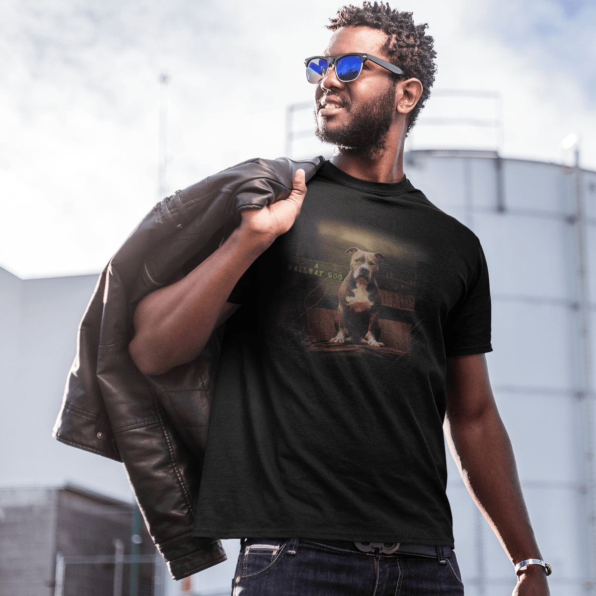 graphic t-shirt featuring an American Staffordshire Terrier seated in a rustic setting with typewriter text reading "A Railway Dog."