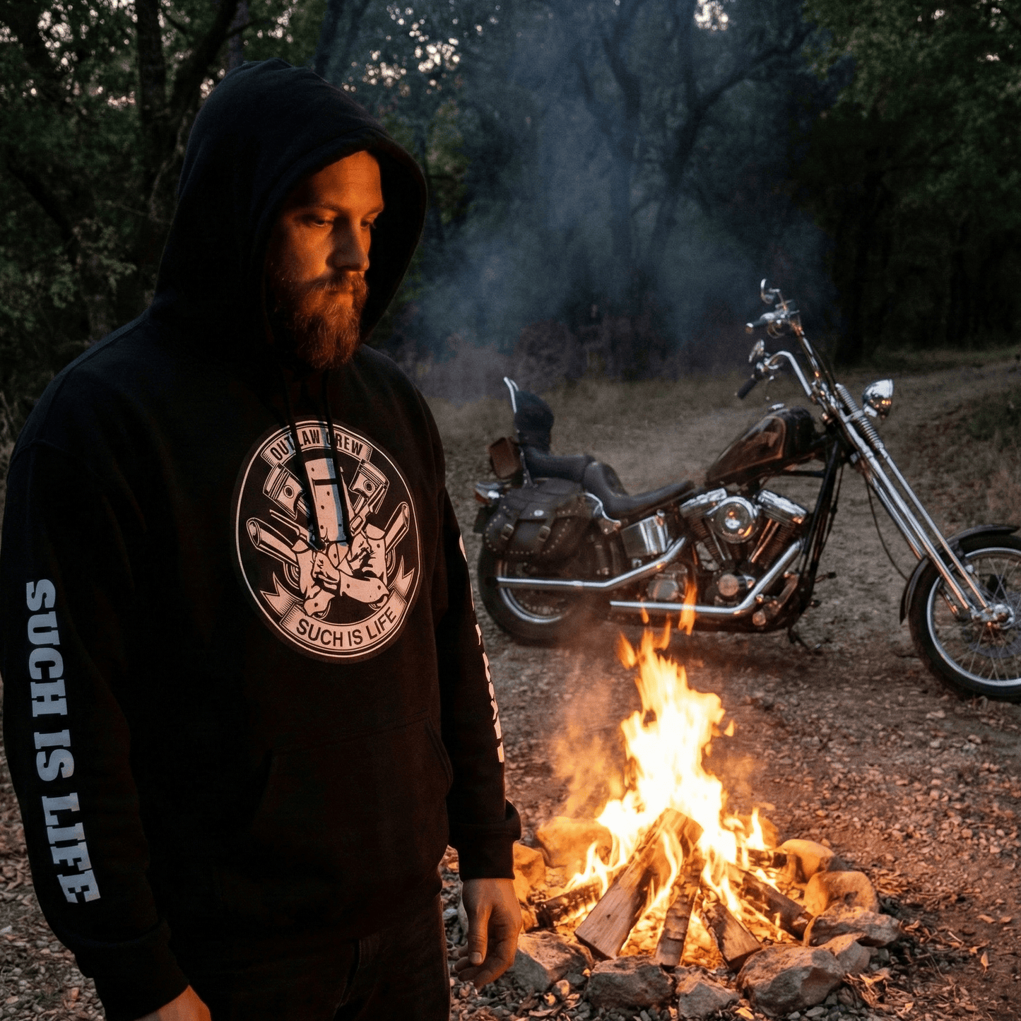 Black pullover hoodie featuring a white circular graphic in the center. The graphic depicts the Ned Kelly iron helmet crossed with engine pistons, surrounded by text "Outlaw Crew" and "Such Is Life." The hoodie features bold white vertical text on the sleeves reading "SUCH IS LIFE" on one arm and "OUTLAW" on the other.
