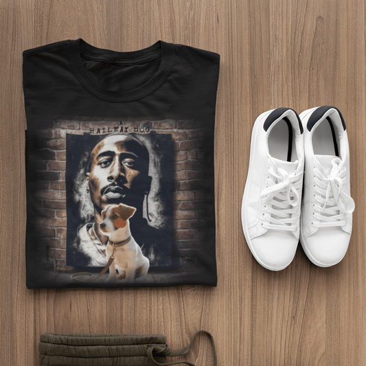 graphic t-shirt folded beside white sneakers, featuring a Jack Russell Terrier puppy in front of a Tupac Shakur brick mural with text reading "A Railway Dog."