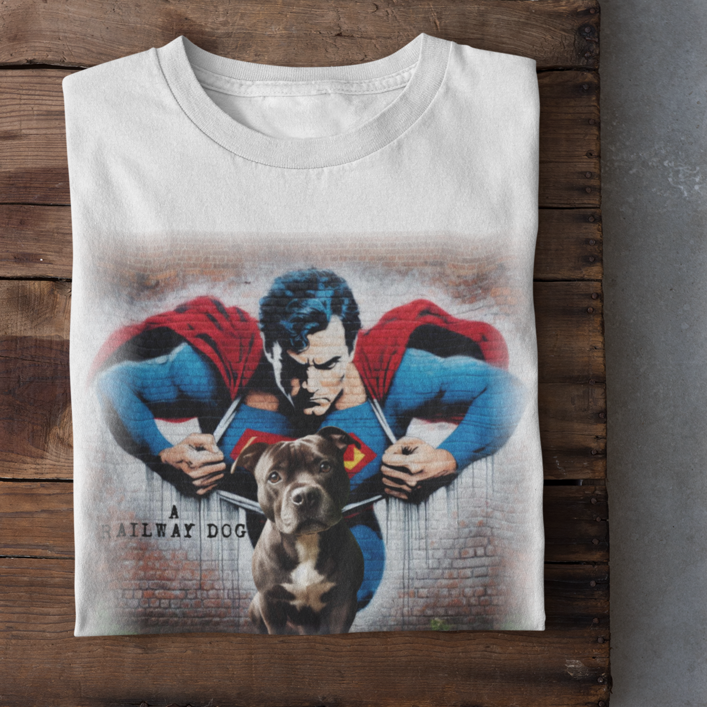 Graphic T-shirt featuring a playful Staffordshire Bull Terrier in a Superman costume, with a bold and colorful comic book style design.