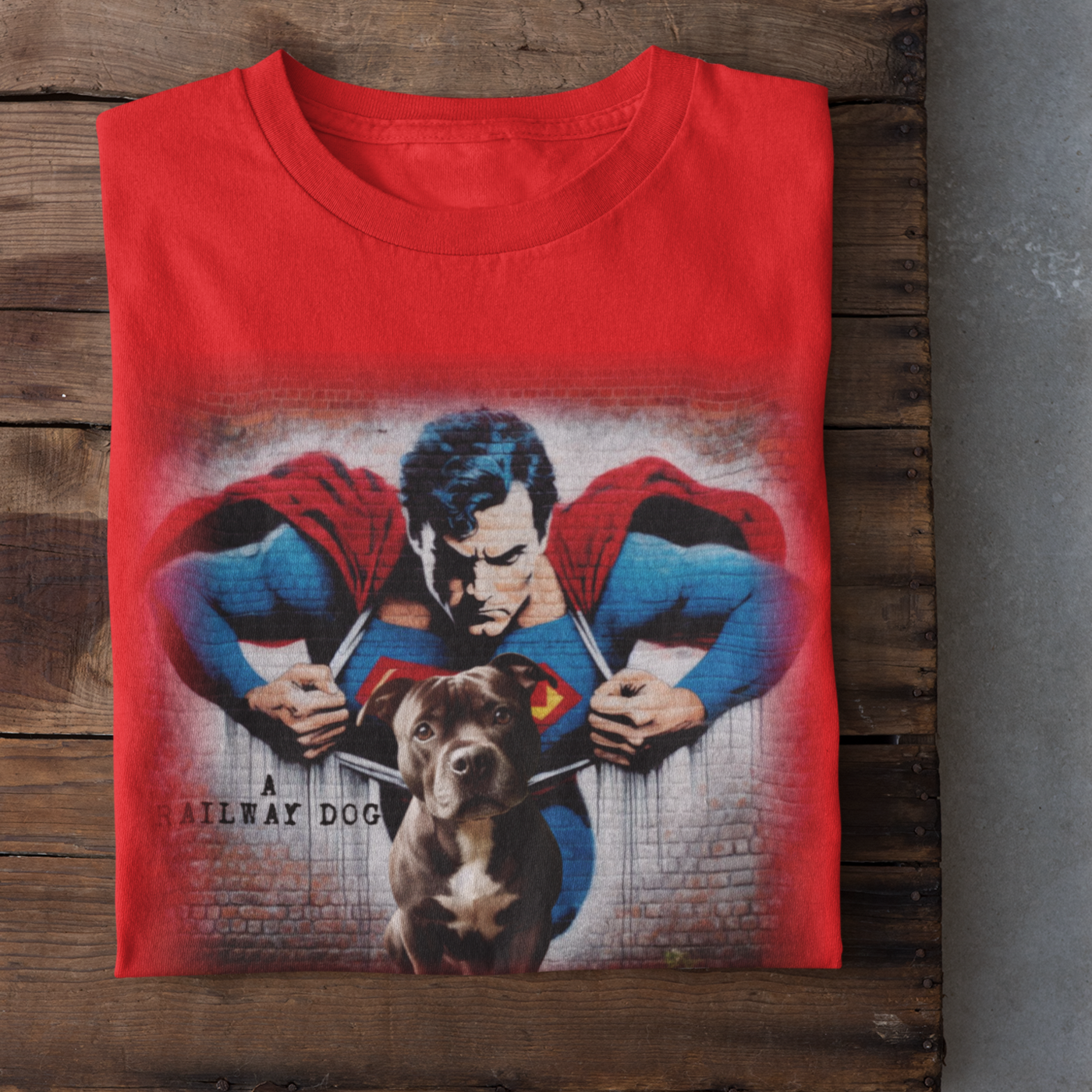 Graphic T-shirt featuring a playful Staffordshire Bull Terrier in a Superman costume, with a bold and colorful comic book style design.