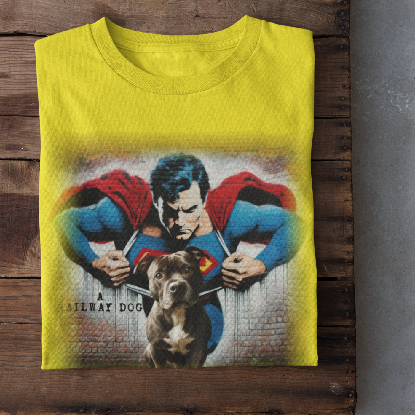 Graphic T-shirt featuring a playful Staffordshire Bull Terrier in a Superman costume, with a bold and colorful comic book style design.