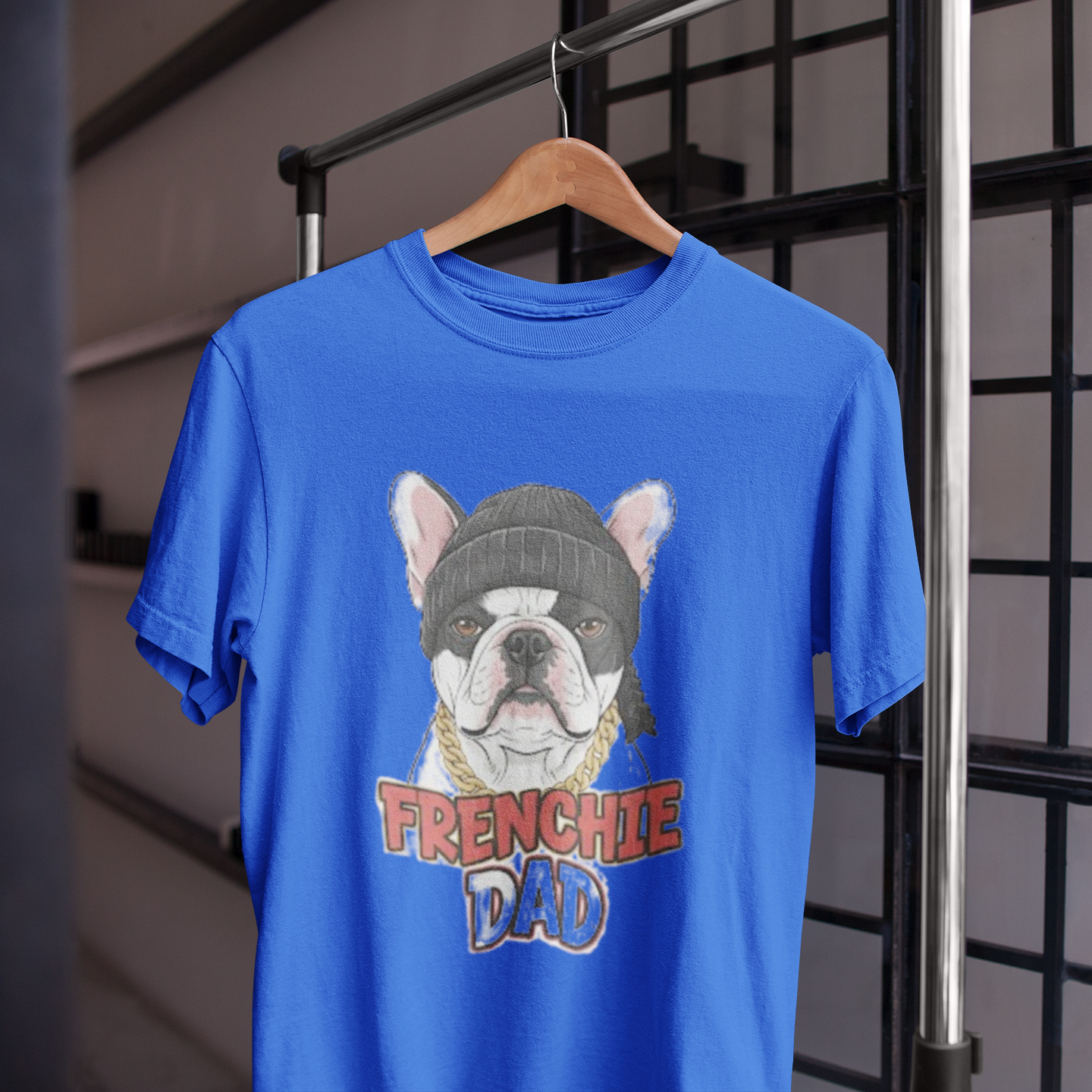 Blue t-shirt with a dog graphic and 'FRENCHIE DAD' text on a hanger.